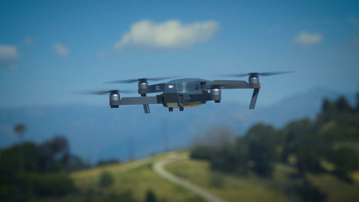 aircraft shallow focus photography of quadcopter on mid air airplane